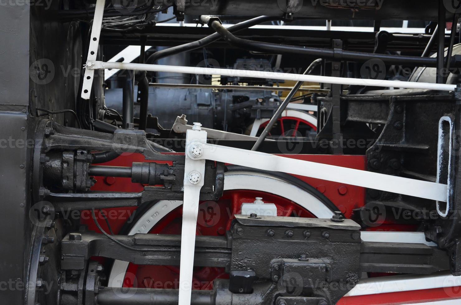 ruedas de la vieja locomotora de vapor negra de la época soviética. el lado de la locomotora con elementos de la tecnología giratoria de trenes antiguos foto