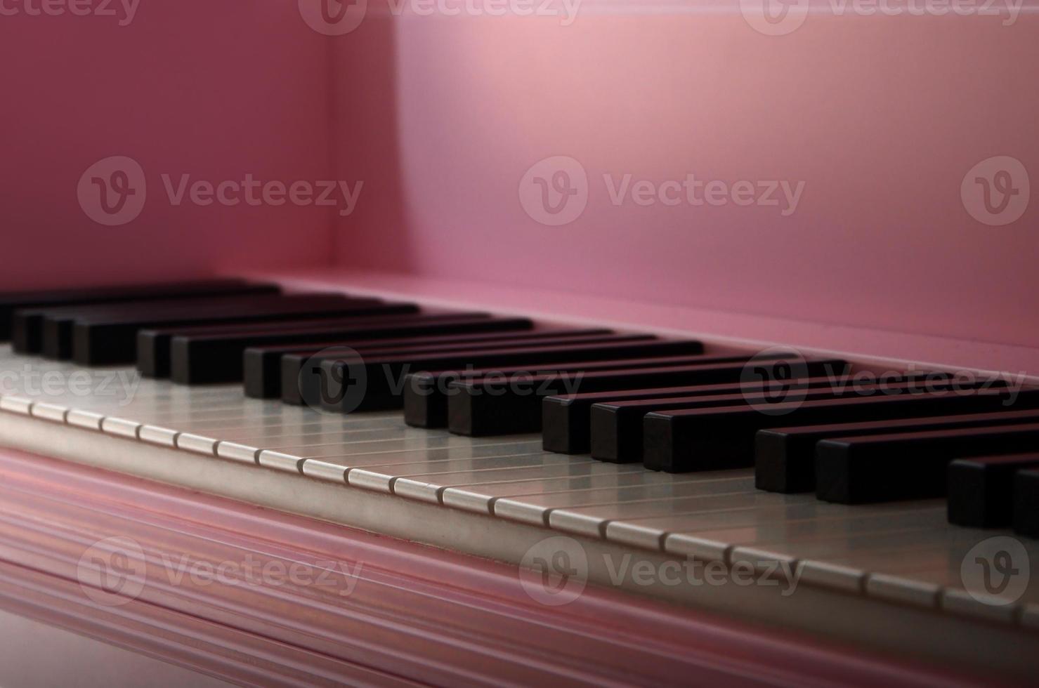 Close-up of the keyboard of a pink piano. Set of white and black buttons photo