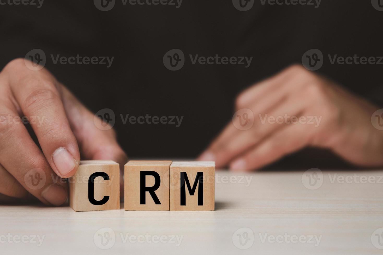 Wooden cubes with CRM Customer relationship management automation system software symbol on desk and copy space.Business concepts. photo