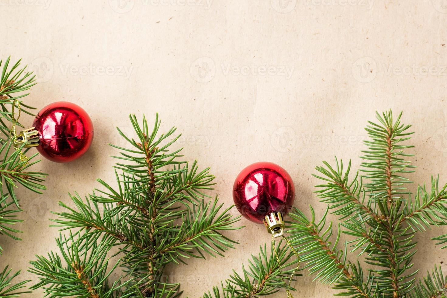 Fir tree branches decorated with red christmas balls as border on a rustic holiday background frame with copy space photo