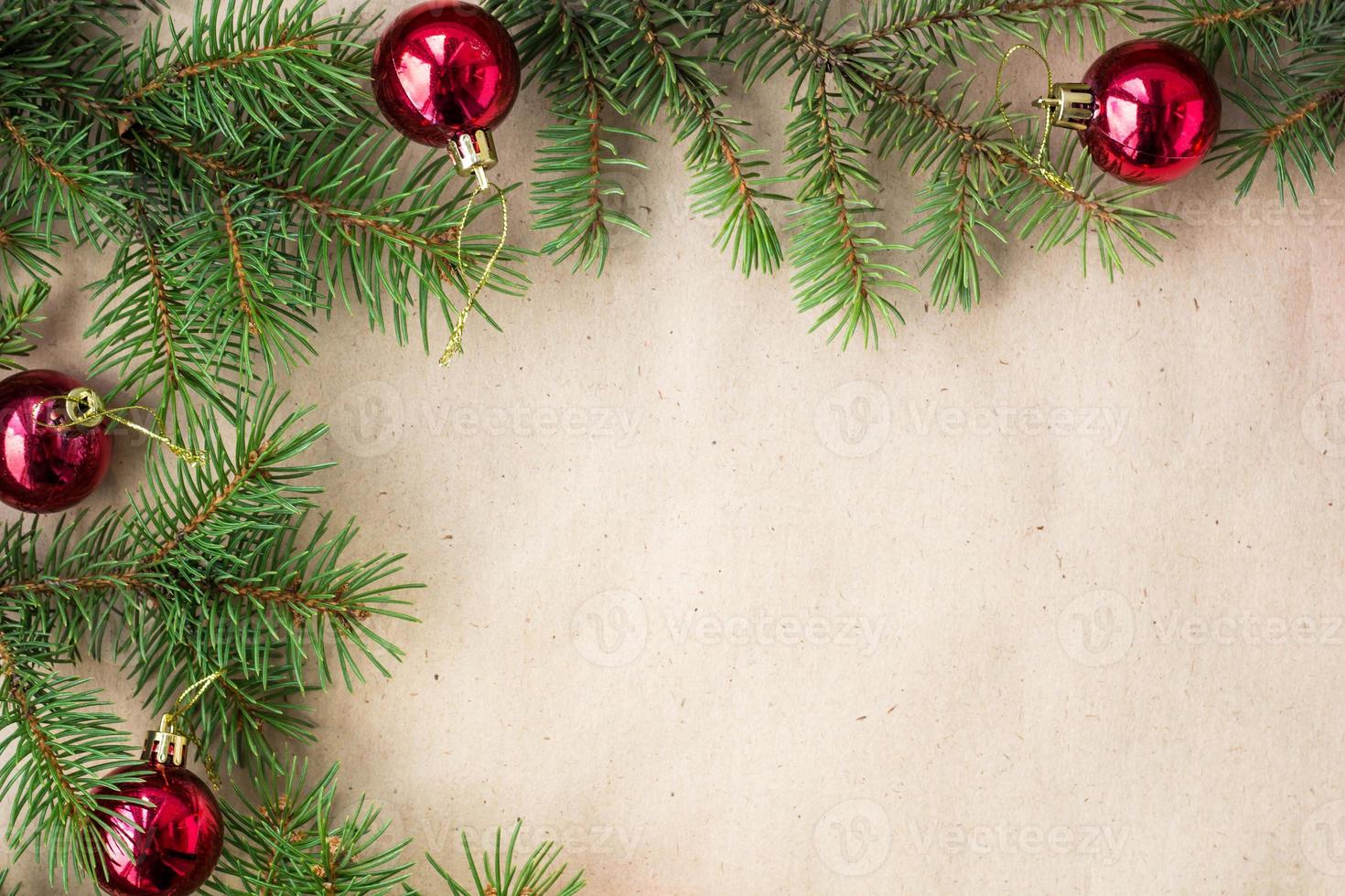 Fir tree branches decorated with red christmas balls as border on a rustic holiday background frame with copy space photo