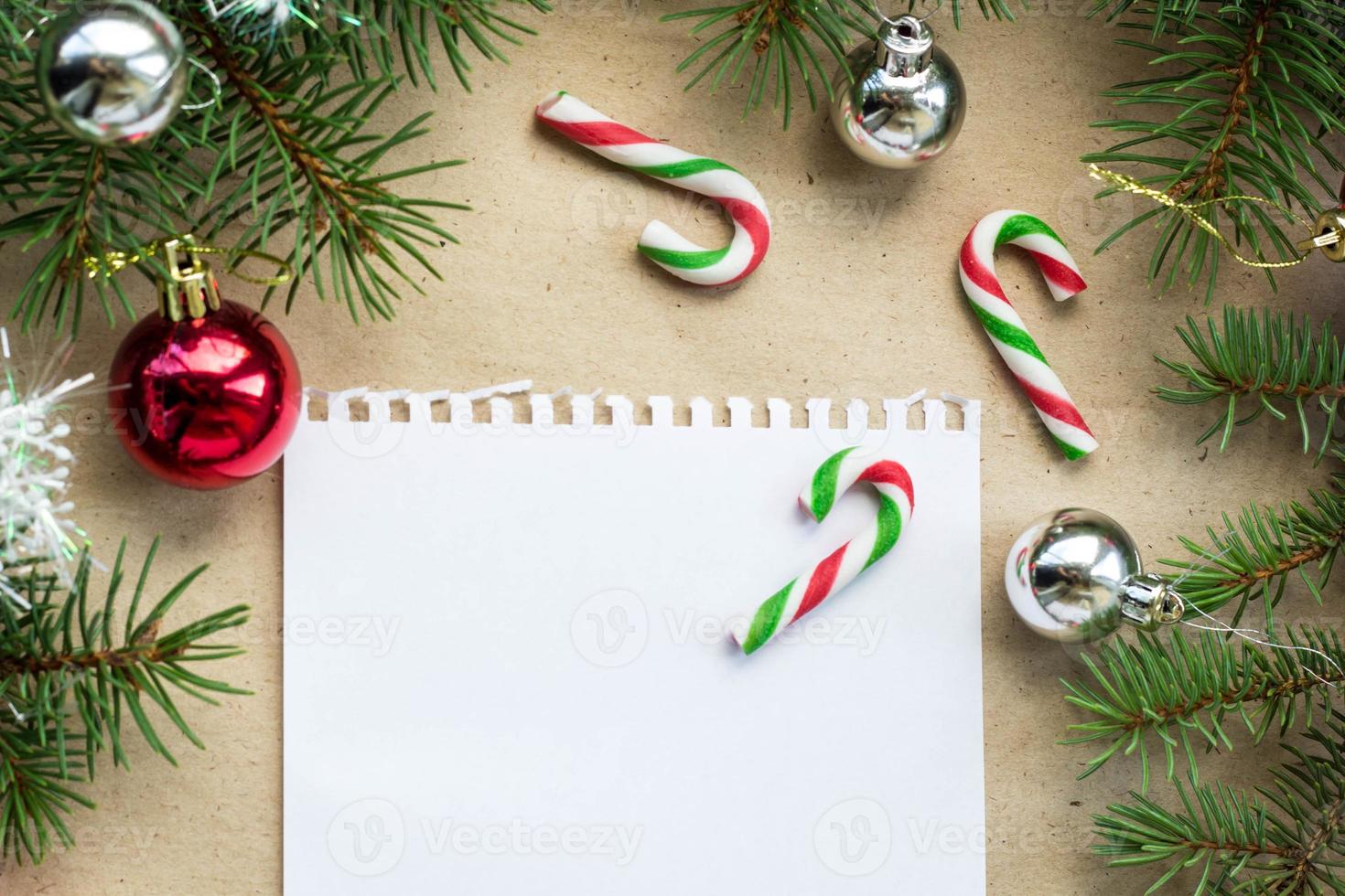 Festive christmas border with red and silver balls on fir branches and snowflakes on rustic beige background photo