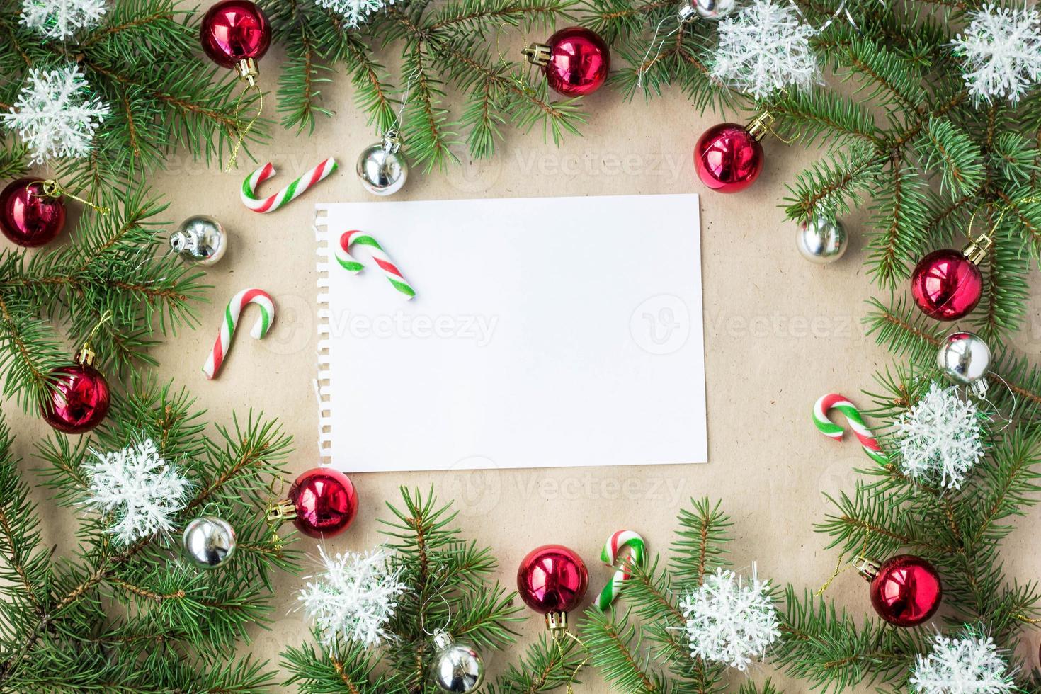 Festive christmas border with red and silver balls on fir branches and snowflakes on rustic beige background photo
