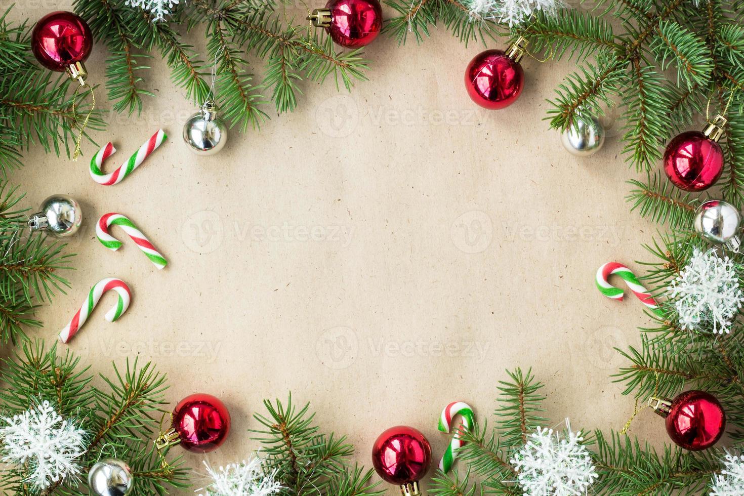 Festive christmas border with red and silver balls on fir branches and snowflakes on rustic beige background photo