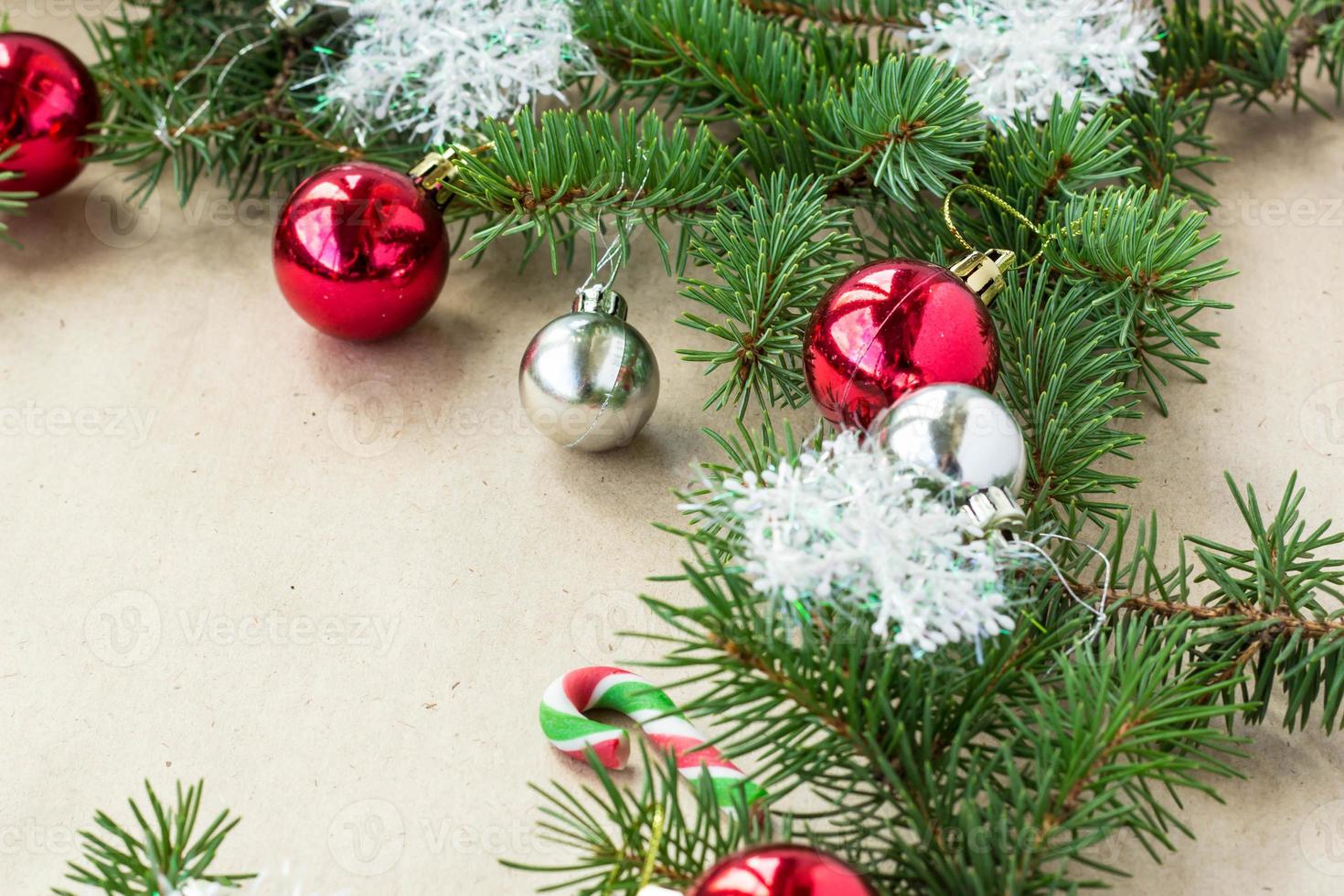 Festive christmas border with red and silver balls on fir branches and snowflakes on rustic beige background photo