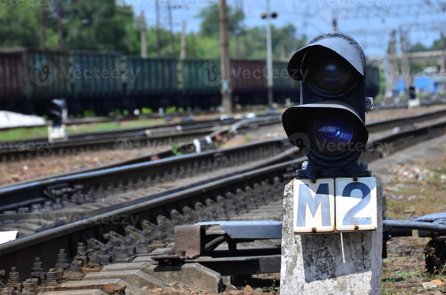 Railway traffic light semaphore against the background of a day railway landscape. Signal device on the railway track photo