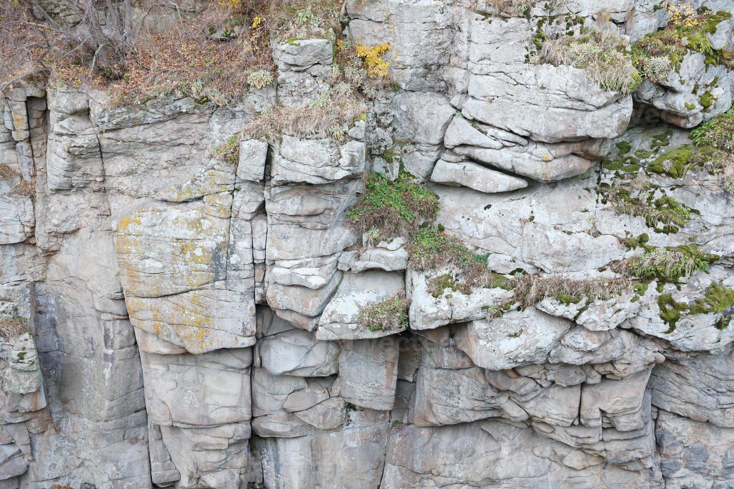 Light coarse natural rock stone background. Mining cliff rough front surface. Big limestone stack backdrop. Heavy grunge damaged granite block texture photo