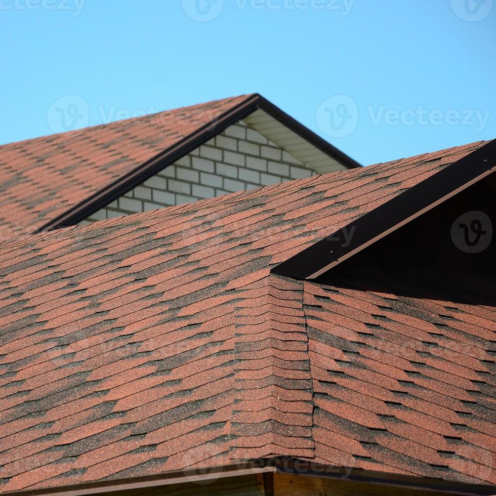 The roof is covered with bituminous shingles of brown color. Quality Roofing photo