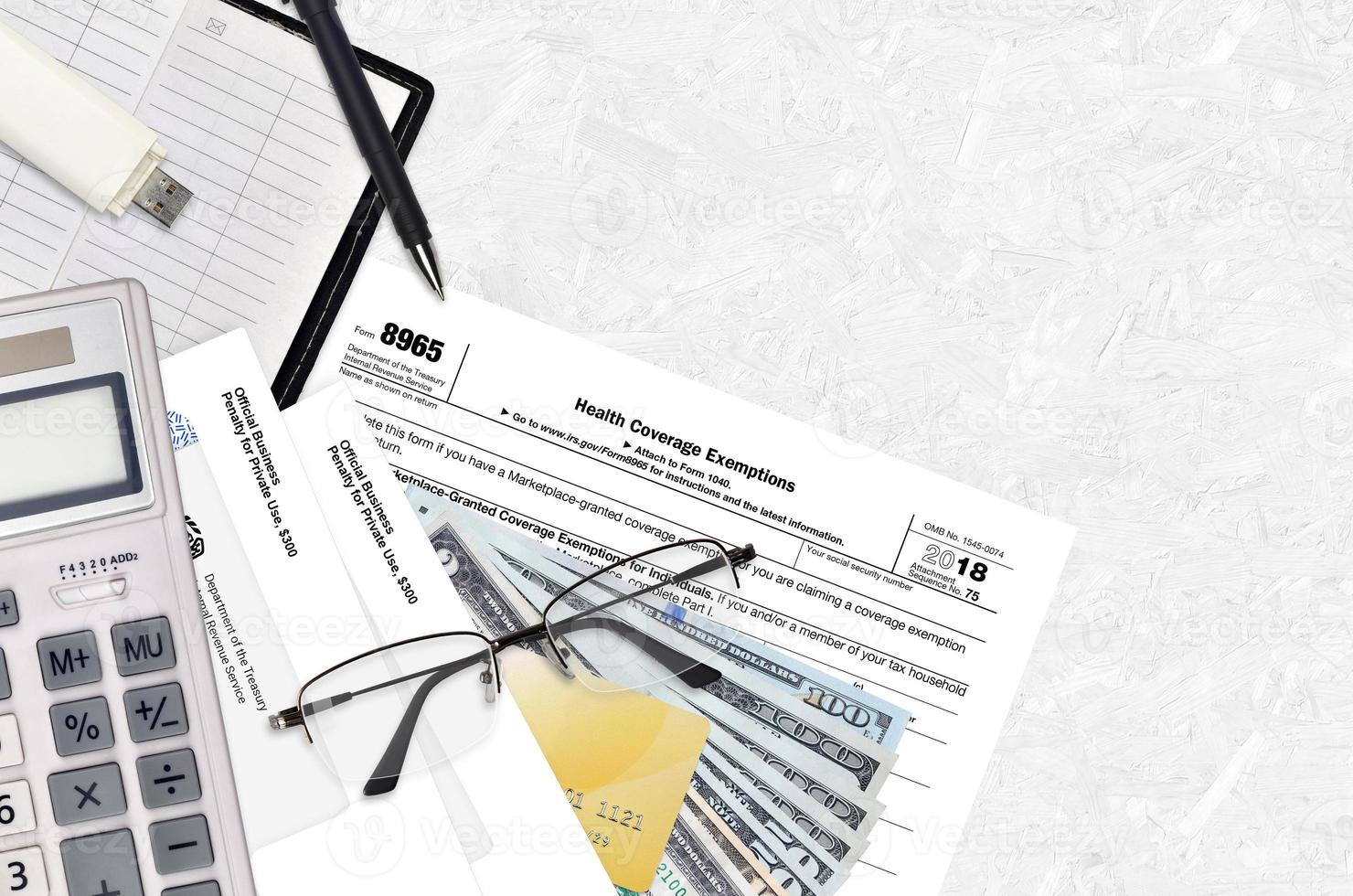 IRS form 8965 Health Coverage Exemptions lies on flat lay office table and ready to fill. U.S. Internal revenue services paperwork concept. Time to pay taxes in United States photo