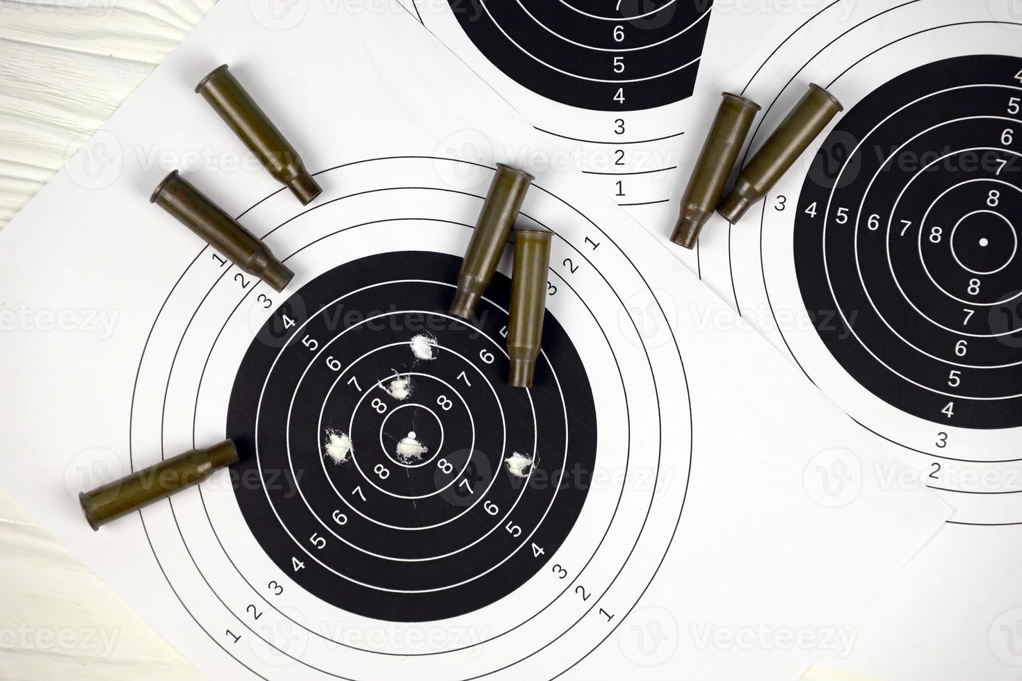 Many bullets on shooting targets on white table in shooting range polygon. Training for aiming and shooting photo