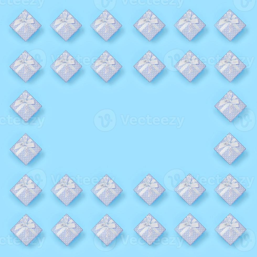 Frame of blue gift boxes lies on texture background of fashion pastel blue color paper in minimal concept photo