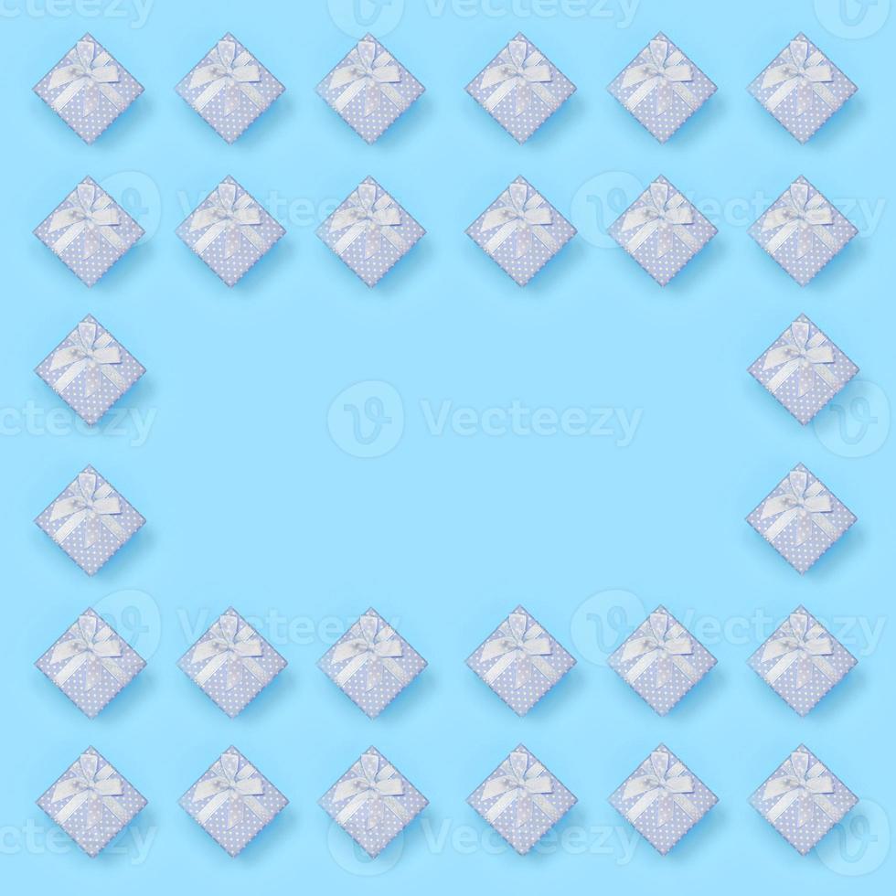 Frame of blue gift boxes lies on texture background of fashion pastel blue color paper in minimal concept photo