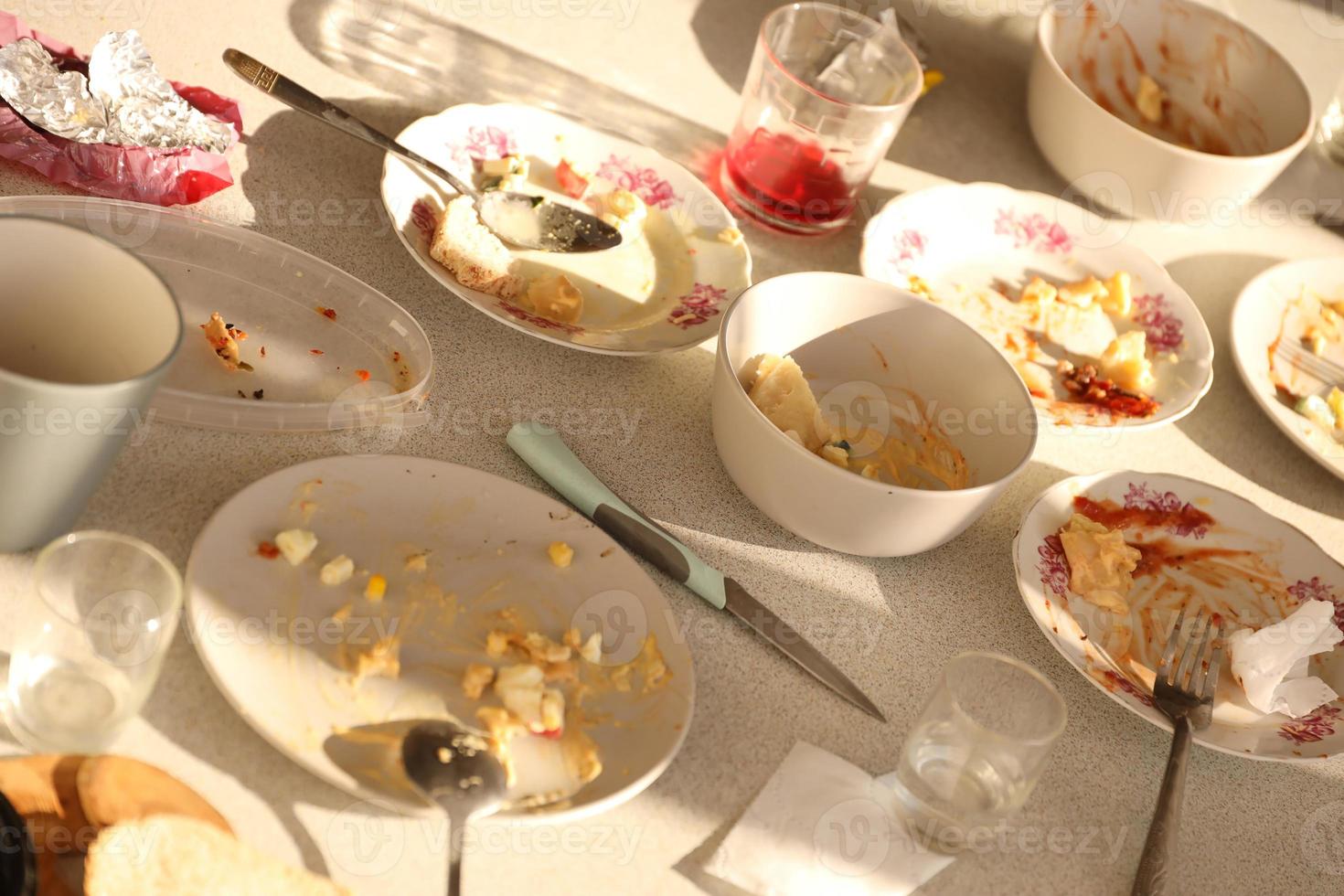 Empty dirty plates with spoons and forks on the table after meal. Banquet ending concept. Unwashed dishes photo