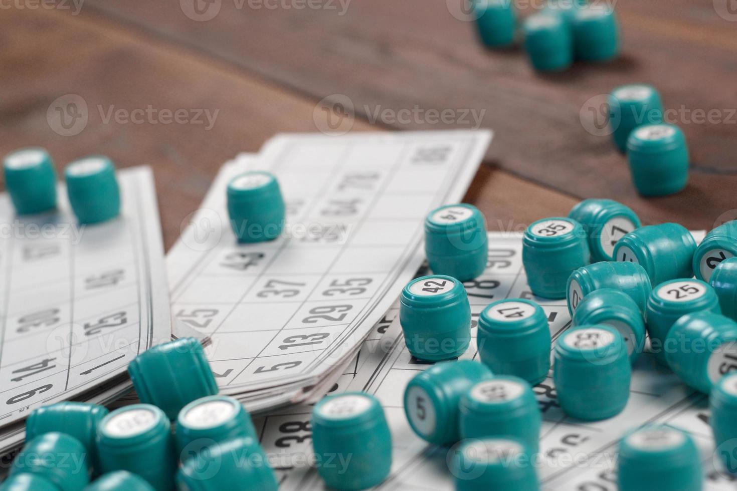 Many barrels with numbers and cards for lotto or russian bingo table game on wooden surface. Russian lotto has similar rules to classical worldwide bingo photo