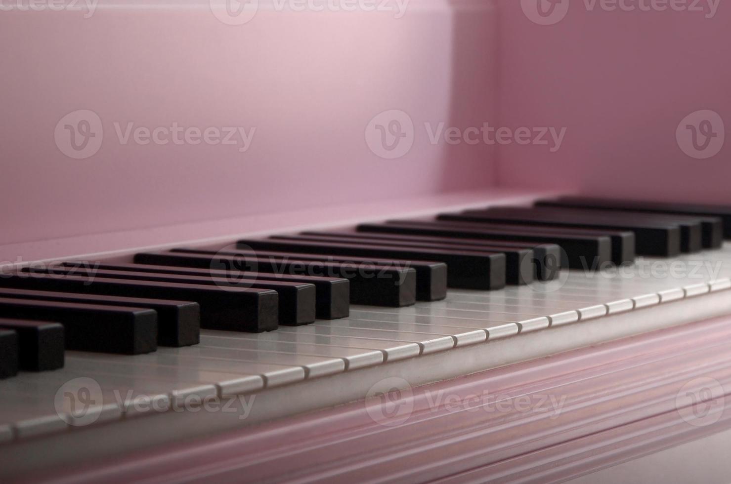 Close-up of the keyboard of a pink piano. Set of white and black buttons photo