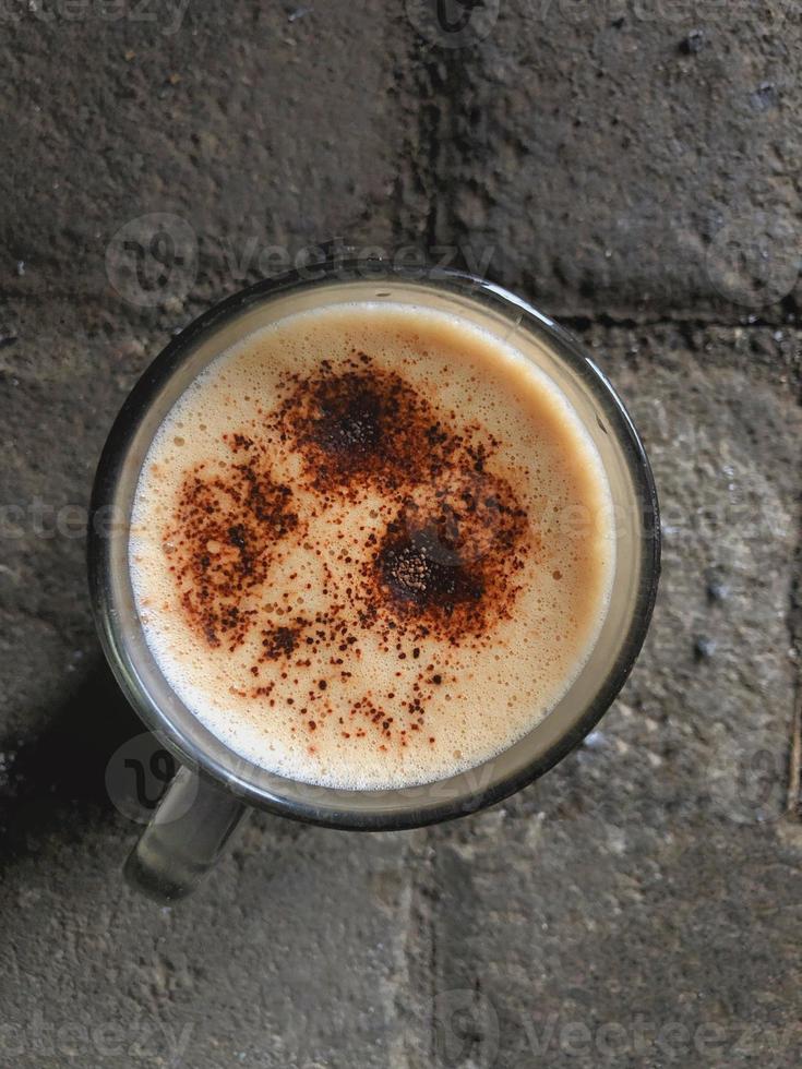 vista de ángulo alto de una taza de café capuchino en el pavimento foto