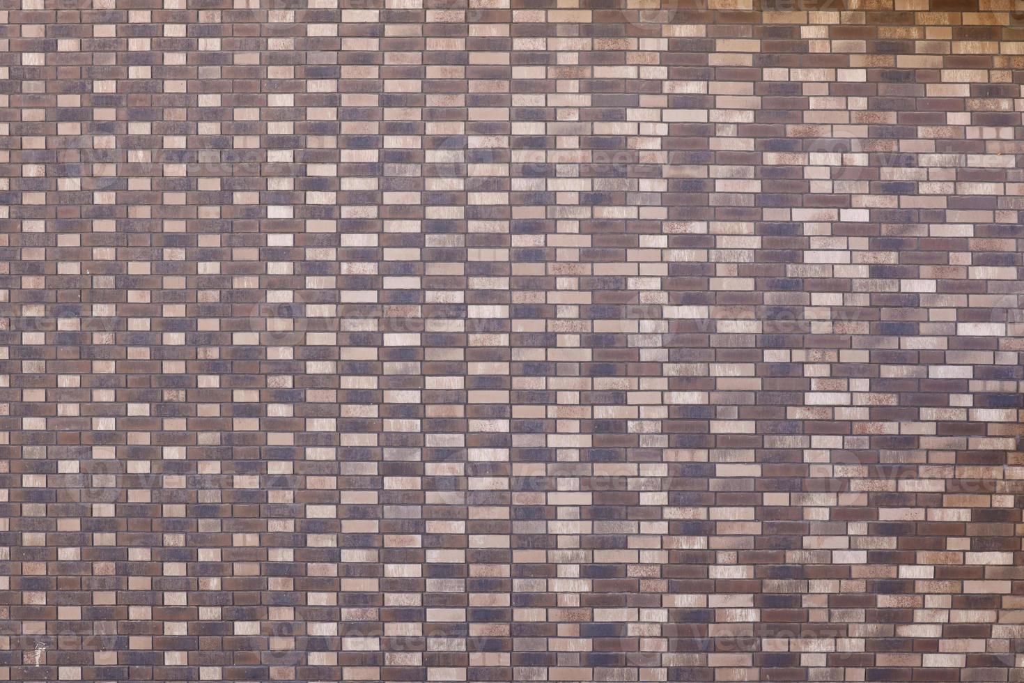 Dark brick wall pattern with chaotic masonry order. Background texture or resource for 3d texturing. Many bricks in big modern stone wall photo