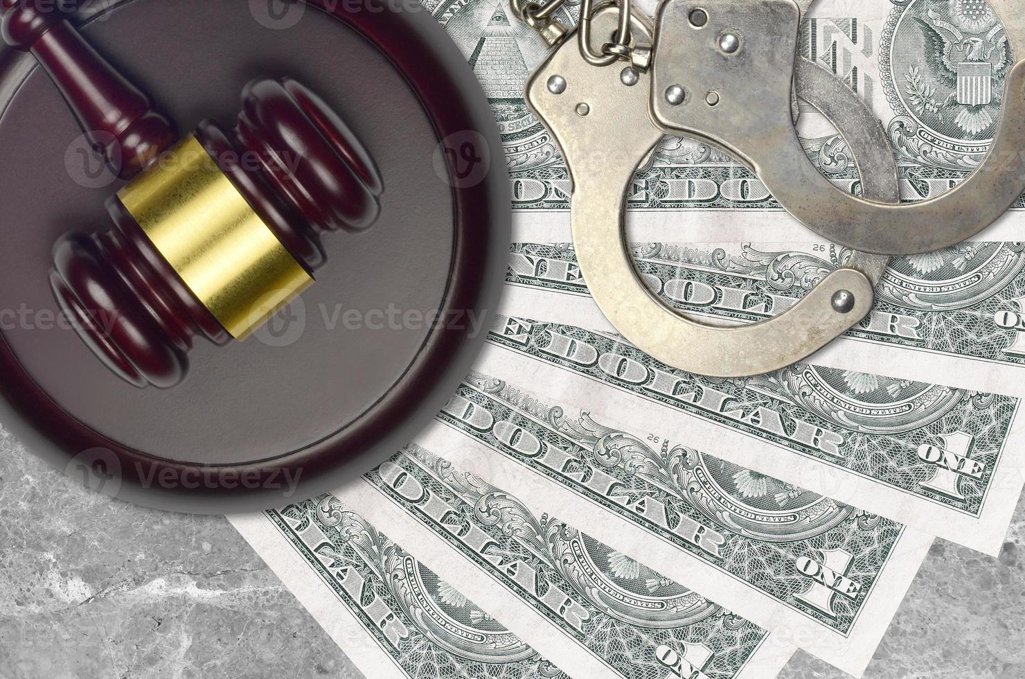 1 US dollar bills and judge hammer with police handcuffs on court desk. Concept of judicial trial or bribery. Tax avoidance photo