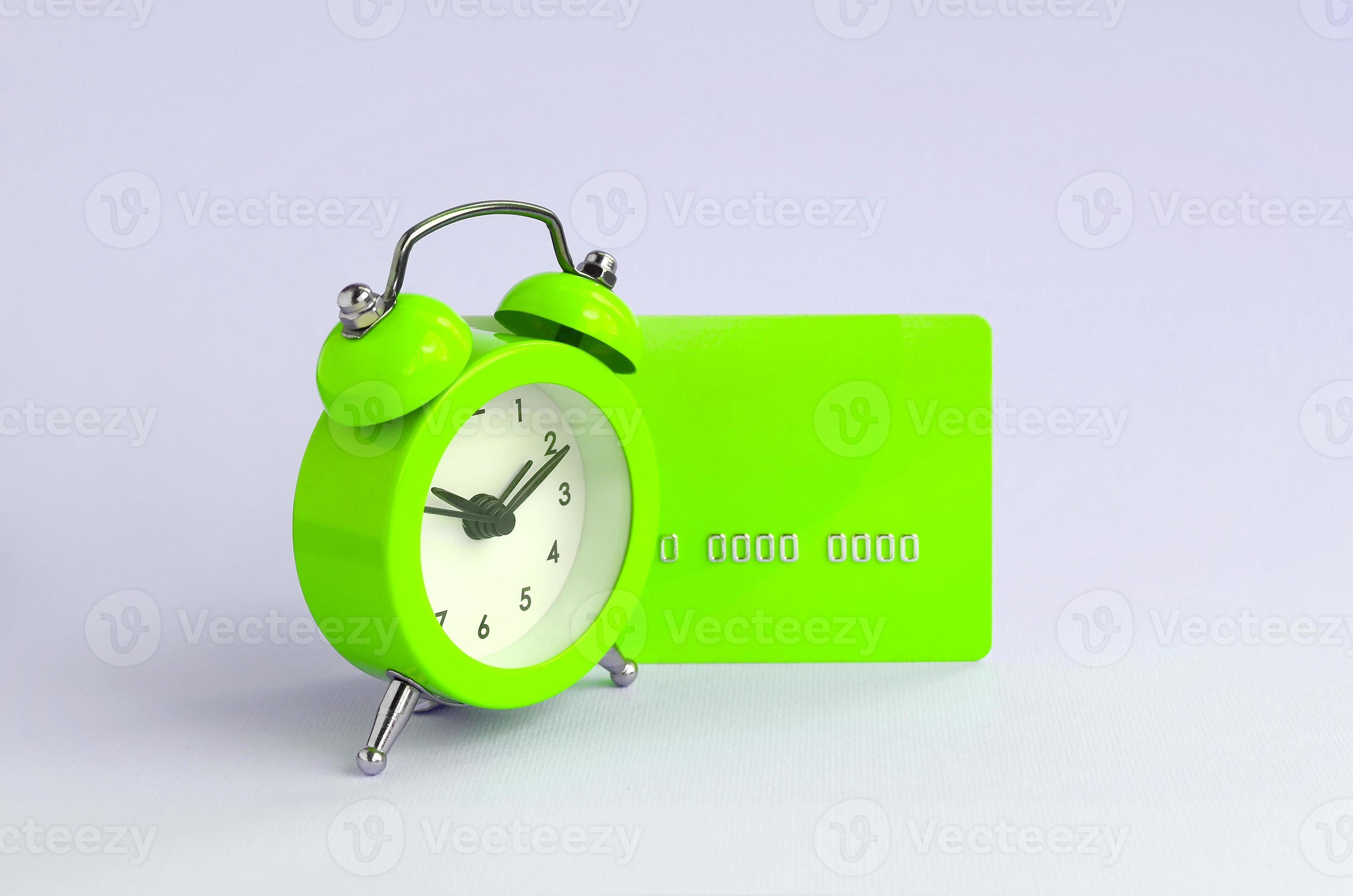 Small green alarm clock and blue credit card 13254281 Stock Photo at
