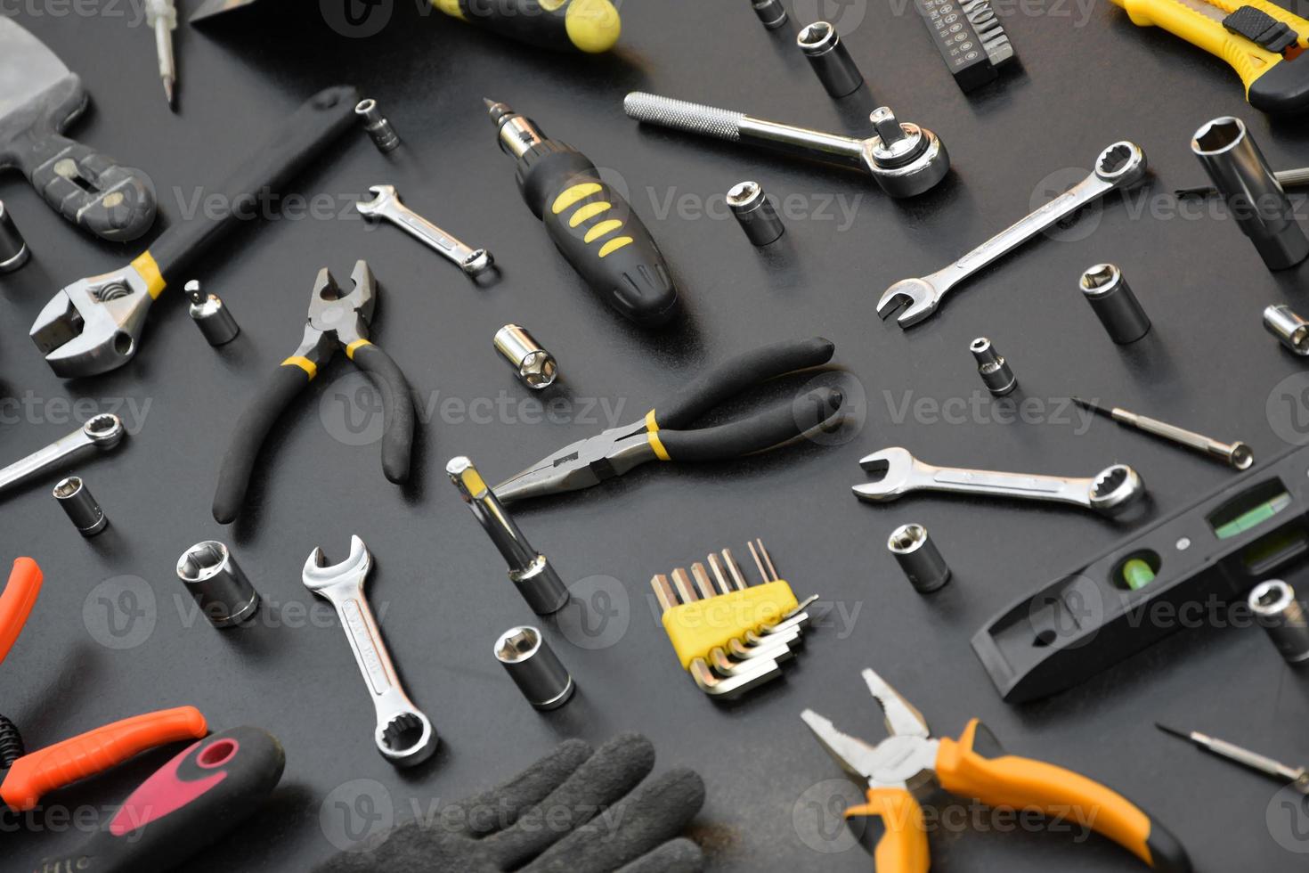 Handyman tool kit on black wooden table. Many wrenches and