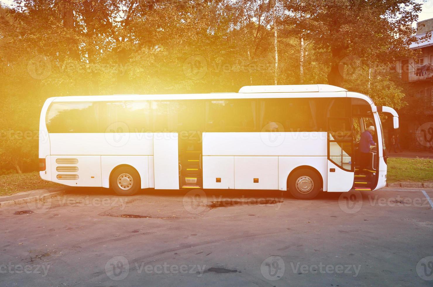 White tourist bus for excursions. The bus is parked in a parking lot near the park photo