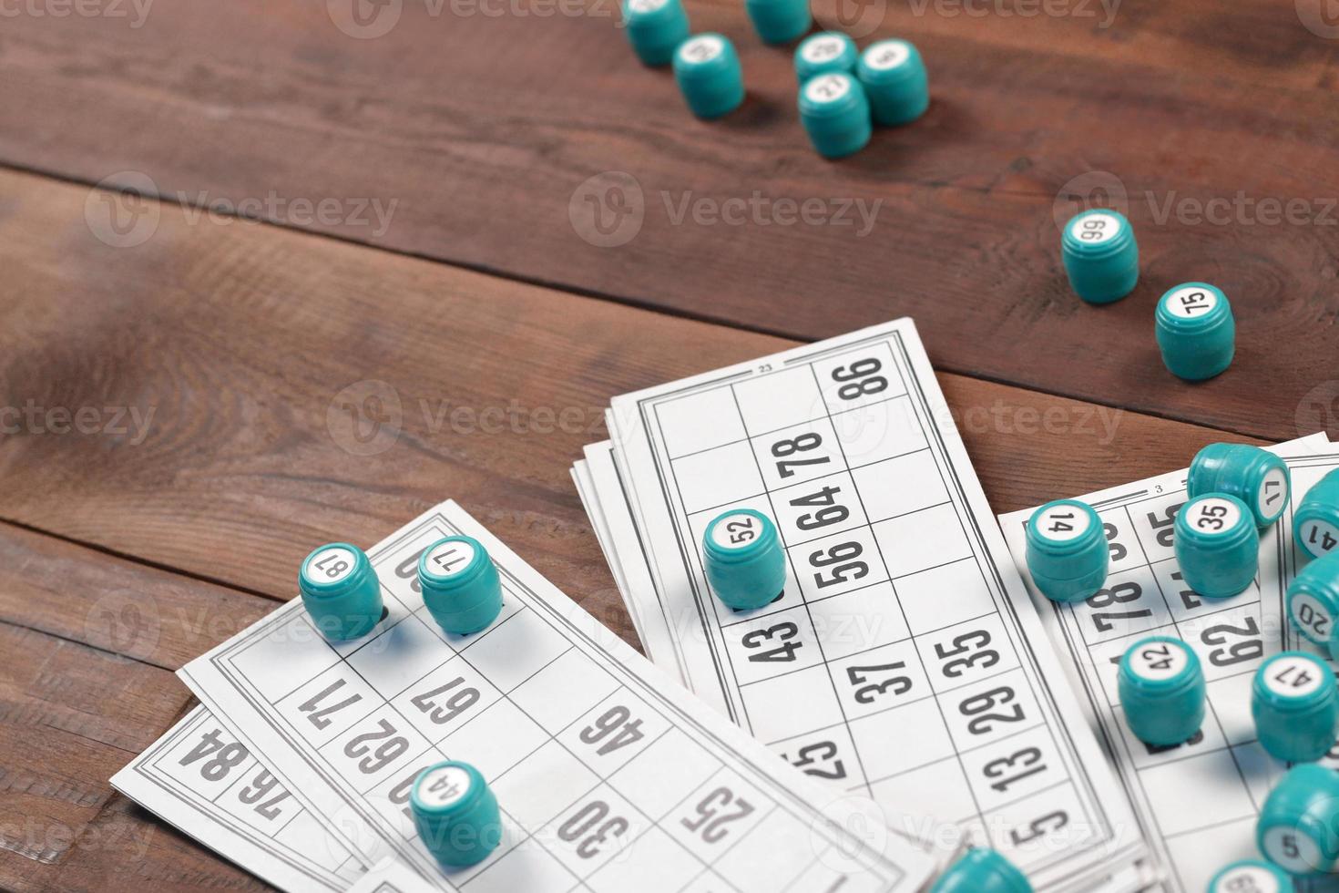 Many barrels with numbers and cards for lotto or russian bingo table game on wooden surface. Russian lotto has similar rules to classical worldwide bingo photo