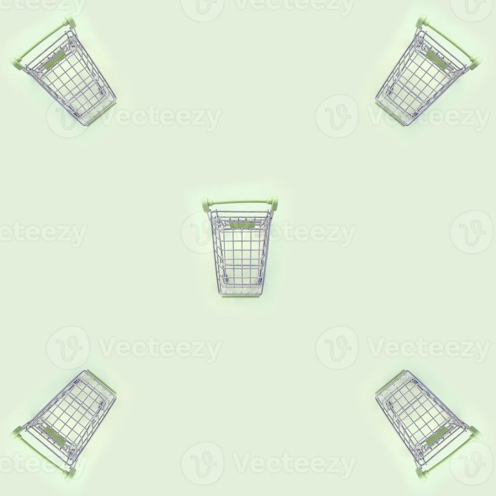 Pattern of many small shopping carts on a lime background photo