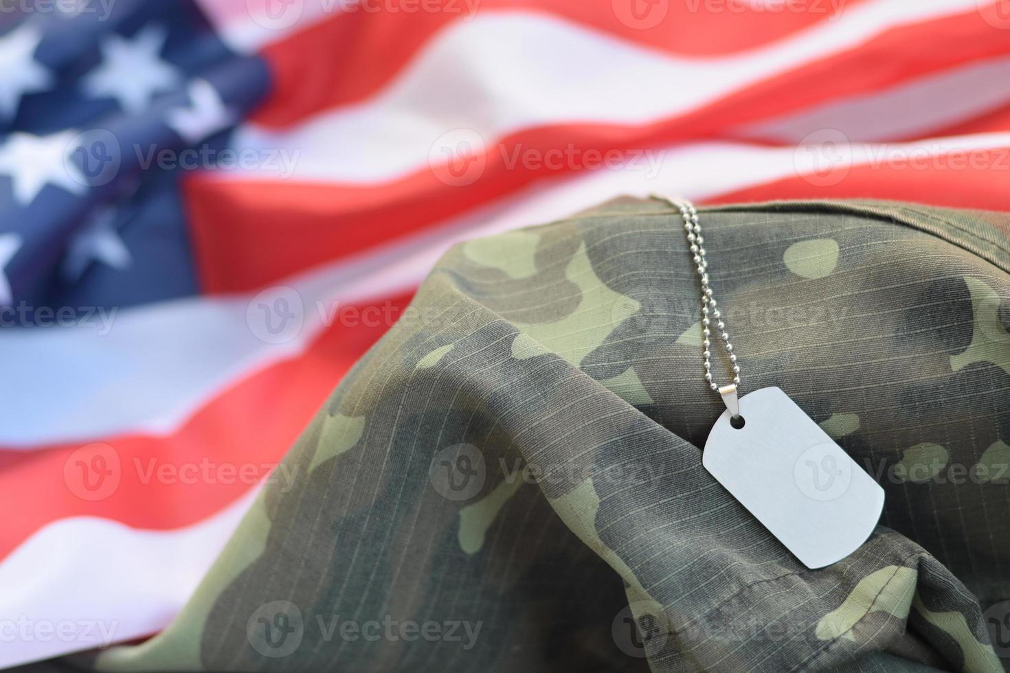 Cuentas militares plateadas con etiqueta de perro en la bandera de tela de los Estados Unidos y uniforme de camuflaje foto