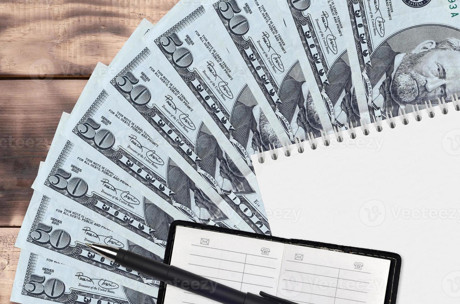 50 US dollars bills fan and notepad with contact book and black pen. Concept of financial planning and business strategy photo