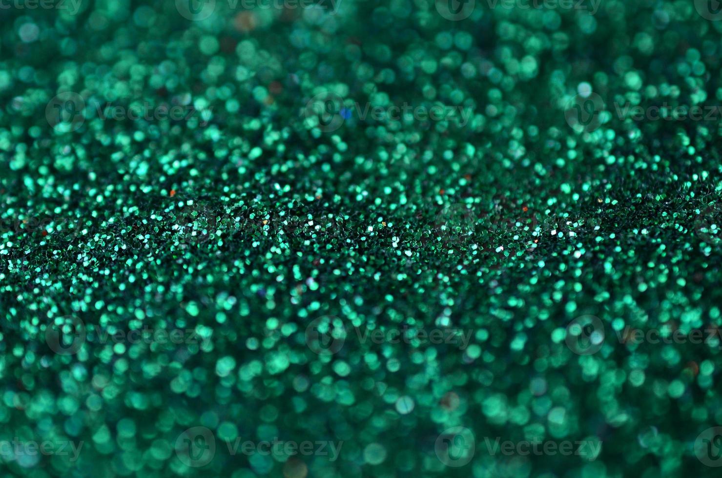 A huge amount of green decorative sequins. Background texture with shiny, small elements that reflect light in a random order. Glitter texture photo
