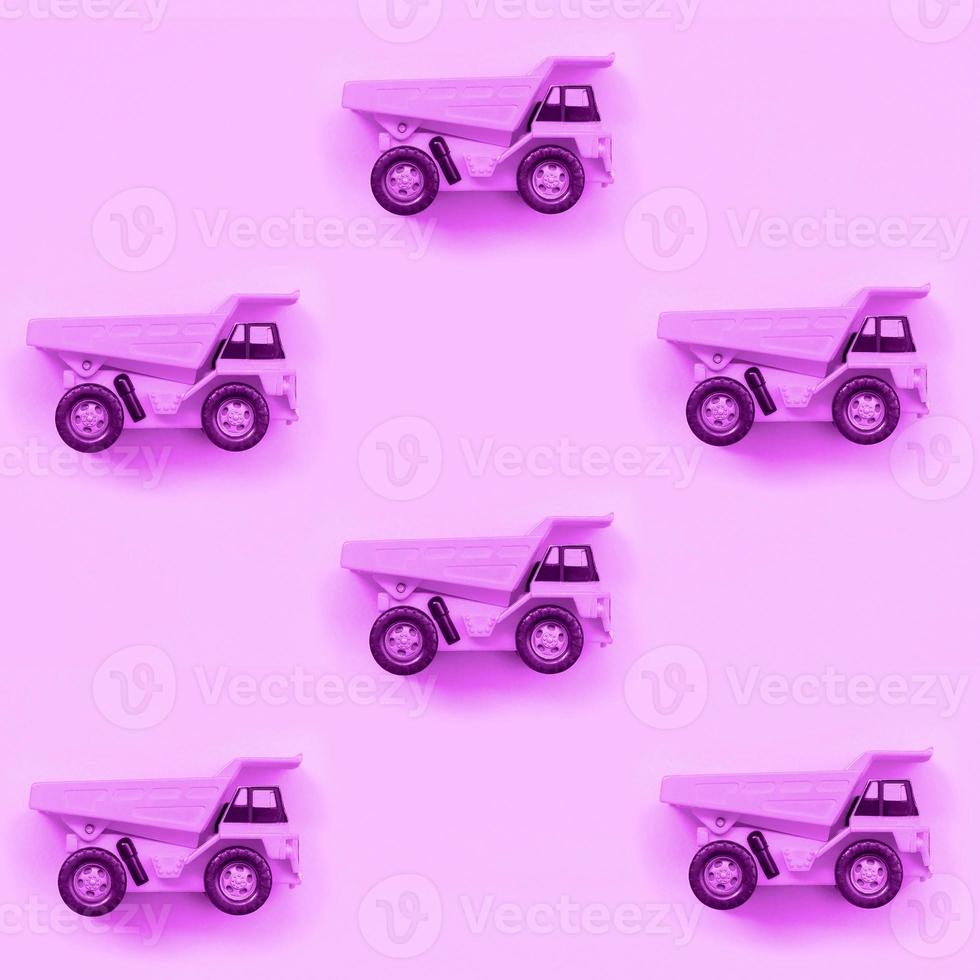 Many small purple toy trucks on texture background of fashion pastel purple color paper photo