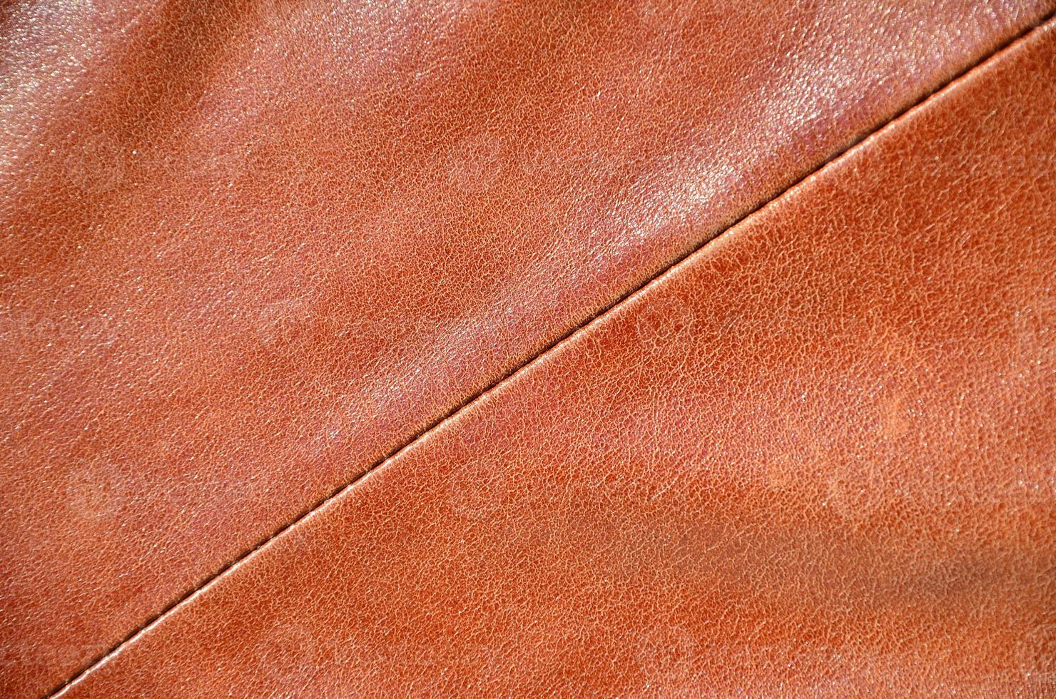 Brown leather texture. Useful as background for any design work. Macro photography of outerwear made of genuine leather photo