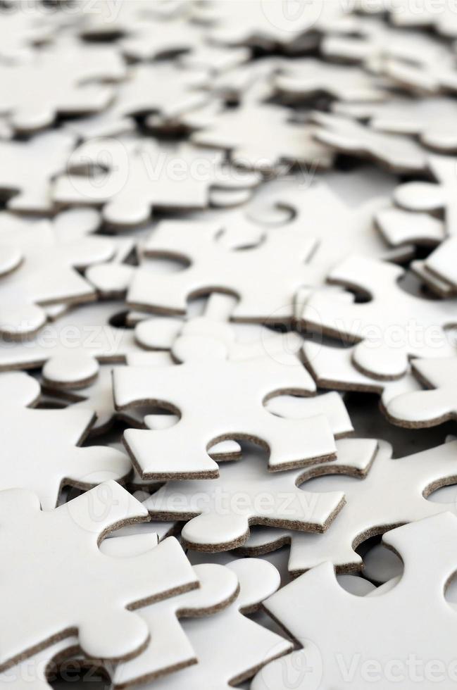 Close-up of a pile of uncompleted elements of a white puzzle. A huge number of rectangular pieces from one large white mosaic photo