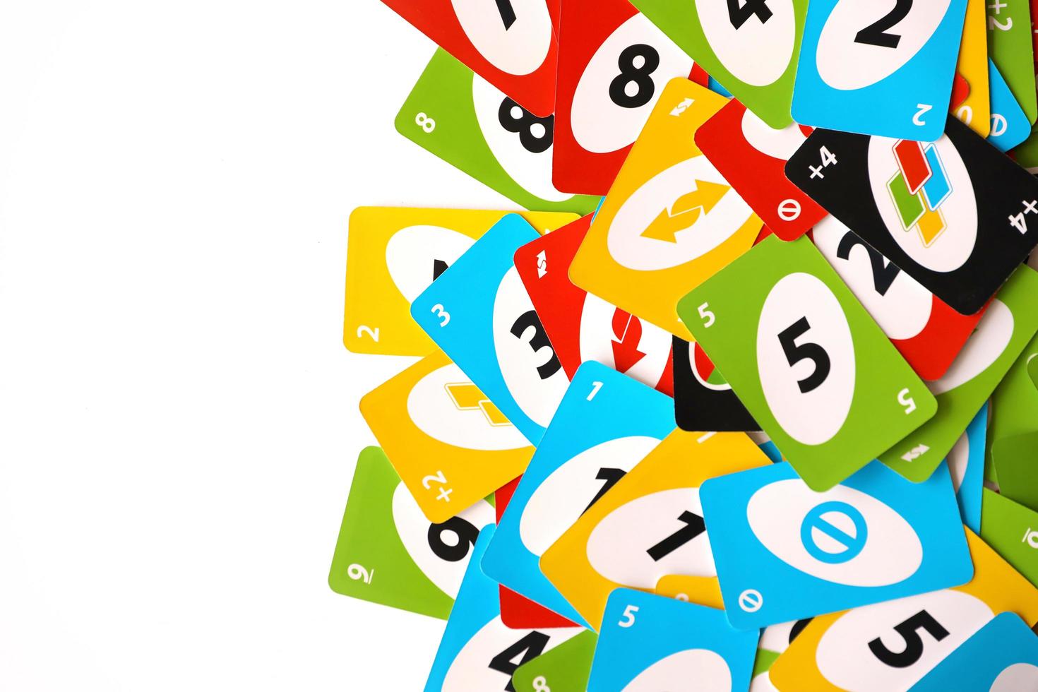 TERNOPIL, UKRAINE - MAY 15, 2022 Many colorful UNO game cards on white background. UNO is an American shedding-type card game that is played with a specially printed deck photo