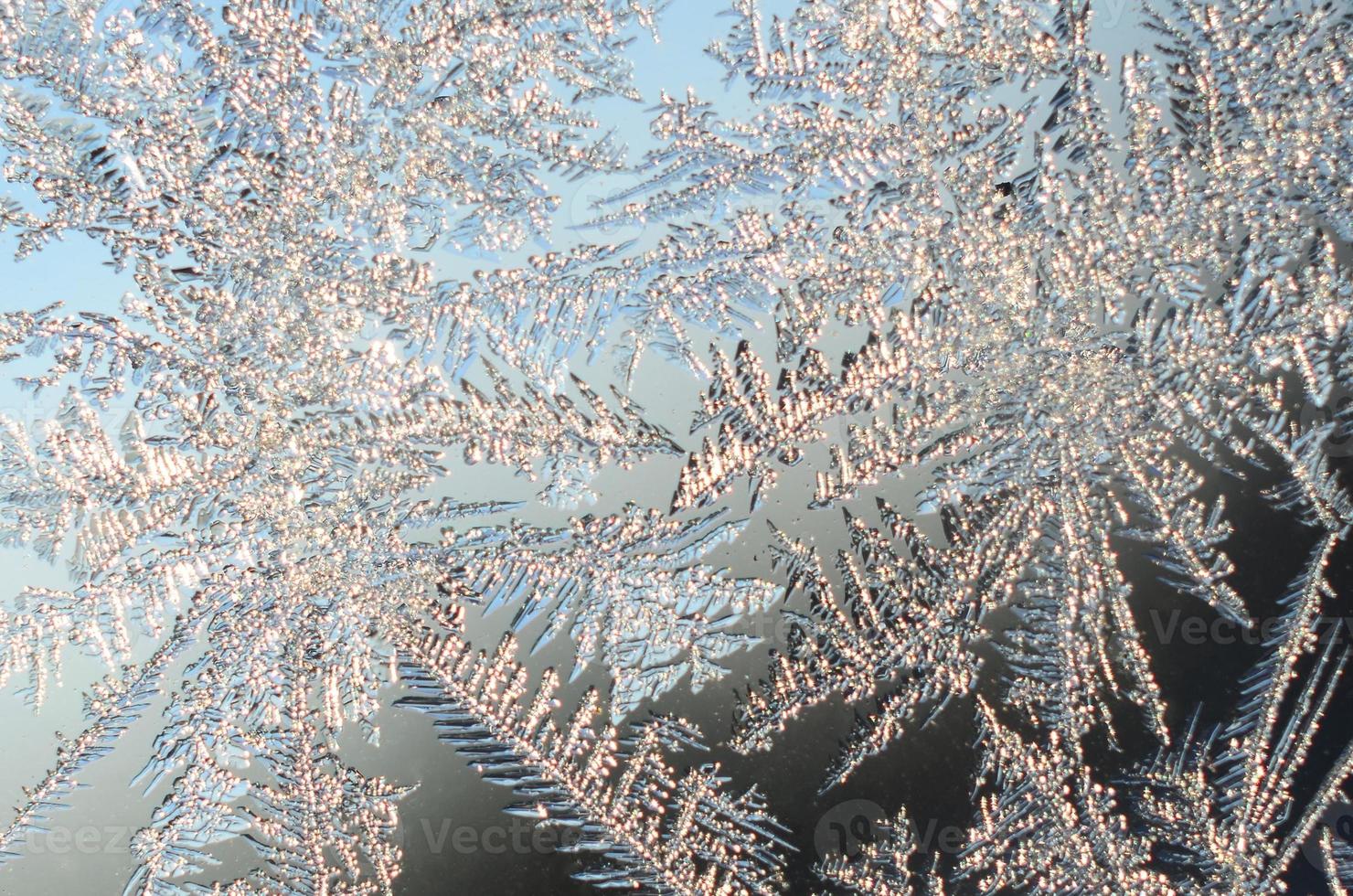 Snowflakes frost rime macro on window glass pane photo