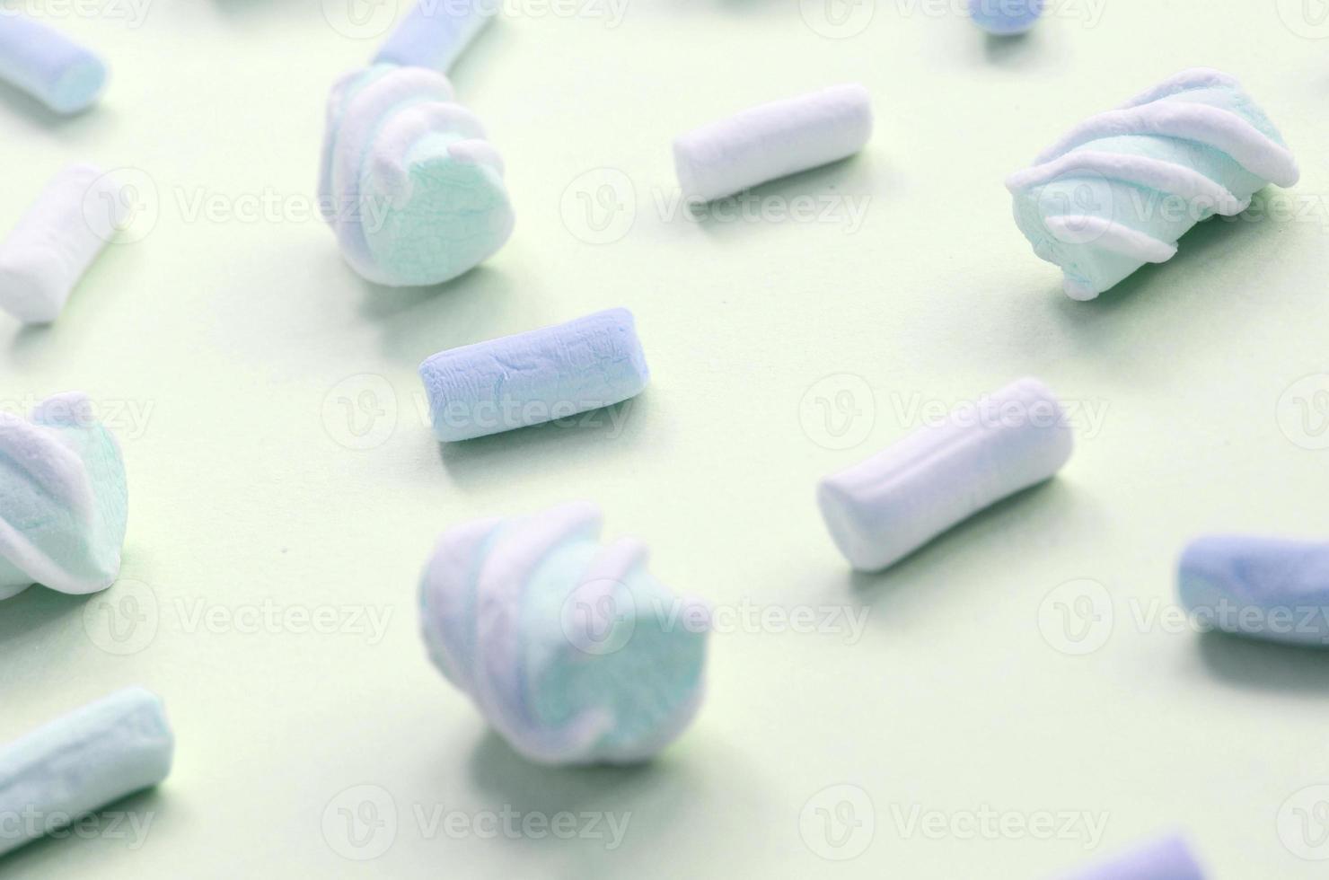 Colorful marshmallow laid out on lime paper background. pastel creative textured pattern photo