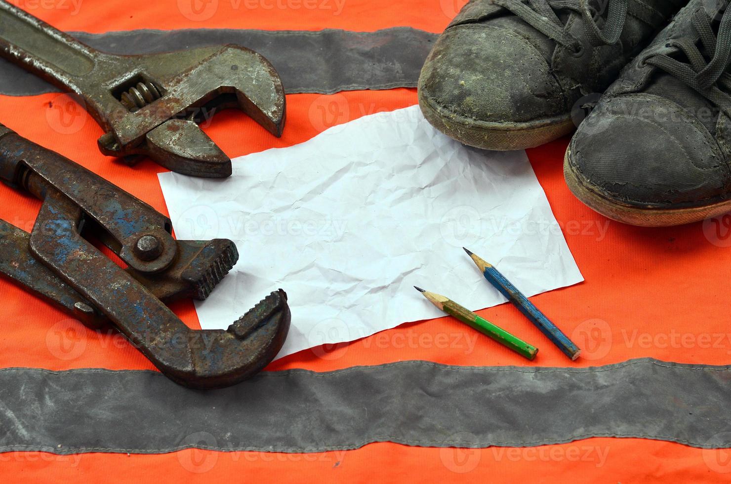 Adjustable wrenches with old boots and a sheet of paper with two photo