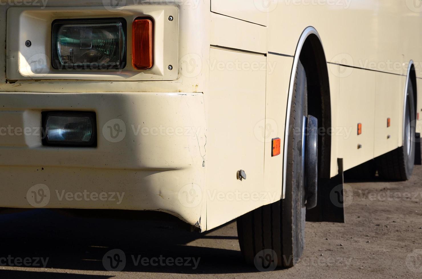 Photo of the hull of a large and long yellow bus. Close-up front view of a passenger vehicle for transportation and tourism