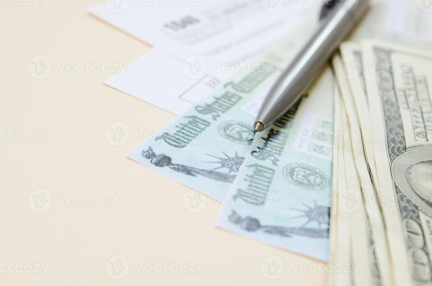 1040 Individual Income tax return form with Refund Check and hundred dollar bills on beige background photo