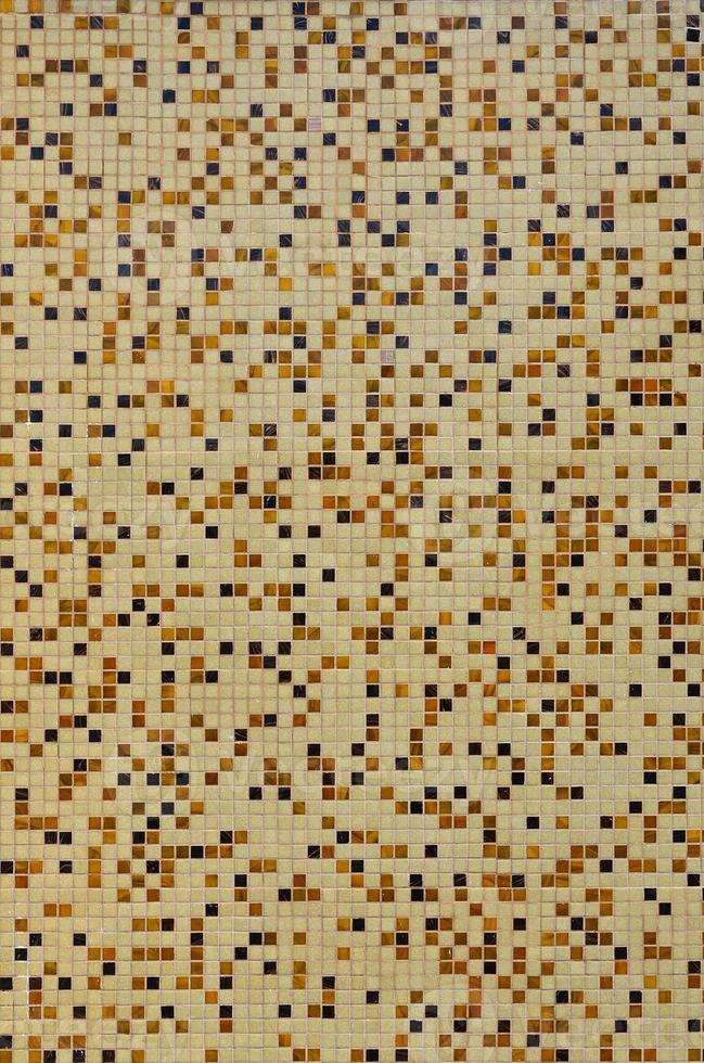 The texture of the wall, decorated with a mosaic of various small square tiles. Abstract pattern of ceramic tiles on the wall photo