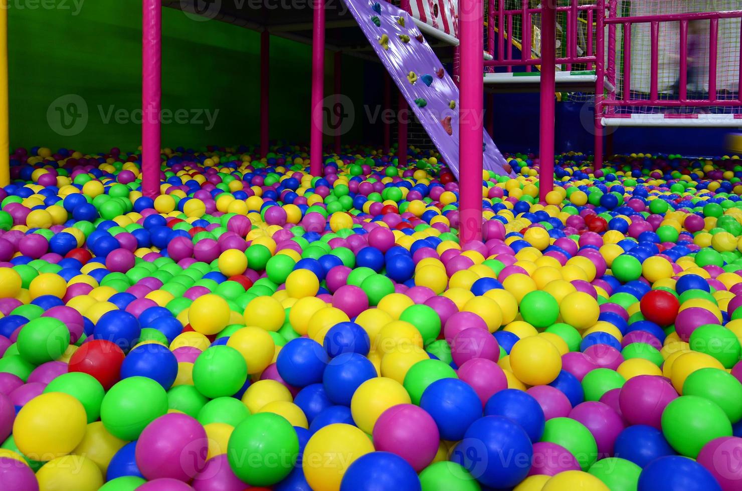 Many colorful plastic balls in a kids' ballpit at a playground photo