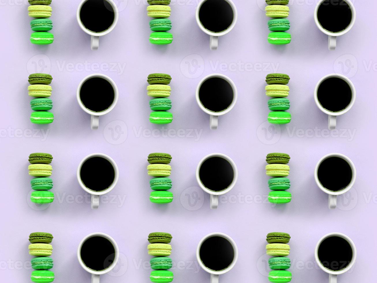 A pattern of many colorful dessert cake macaroon and coffee cups on trendy pastel lilac background top view photo