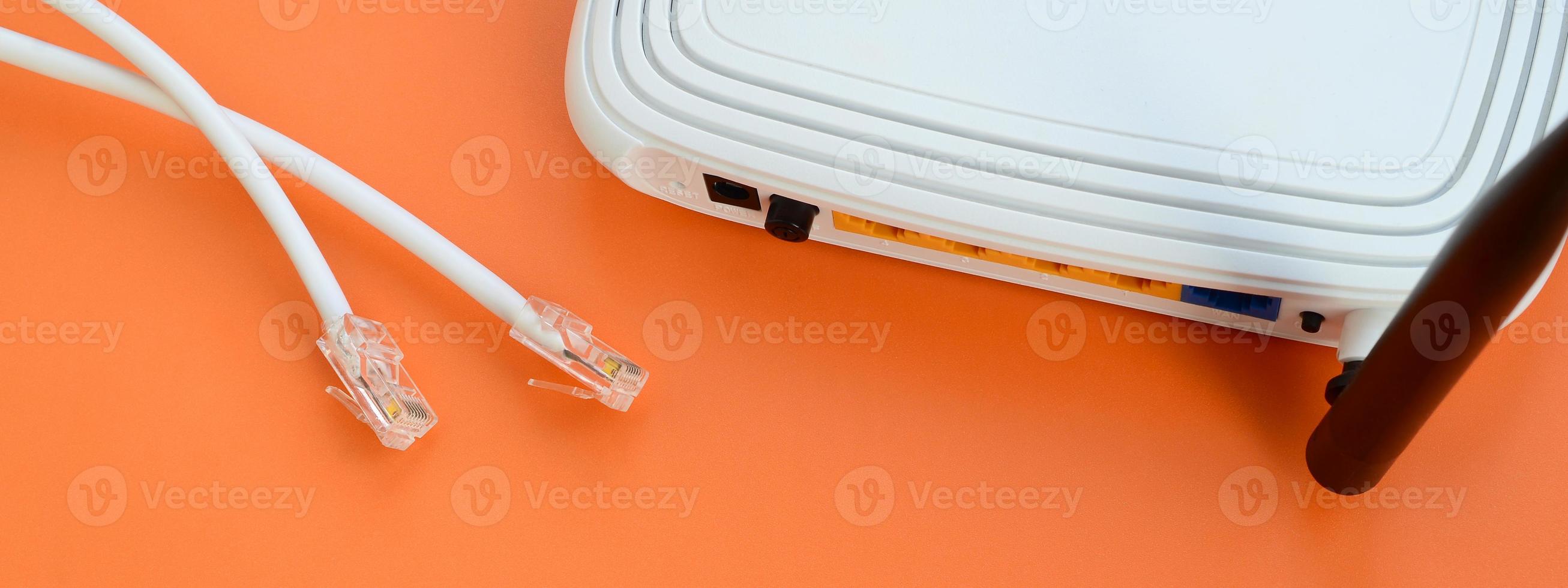 Internet router and Internet cable plugs lie on a bright orange background. Items required for Internet connection photo