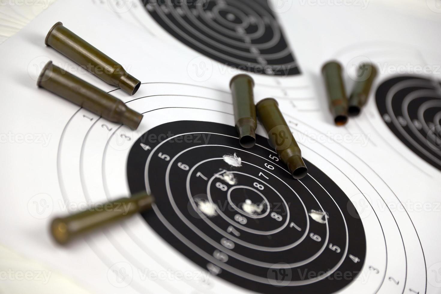 Many bullets on shooting targets on white table in shooting range polygon. Training for aiming and shooting photo