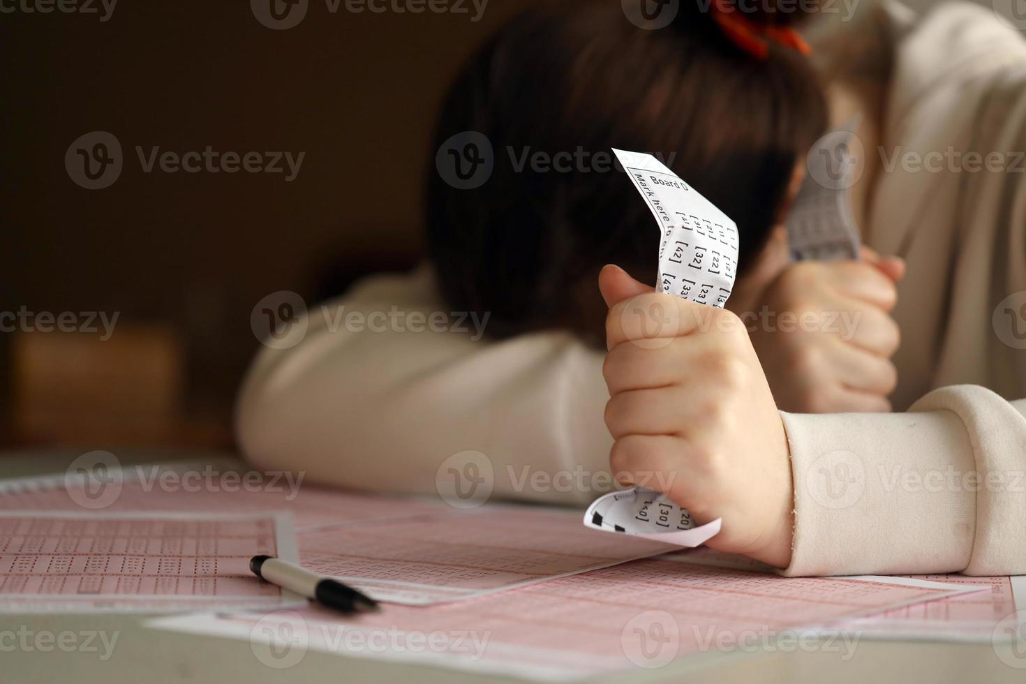 A sad young girl suffers from a loss after looking the unlucky result of the lottery gambling. The concept of losing the lottery and spend money photo