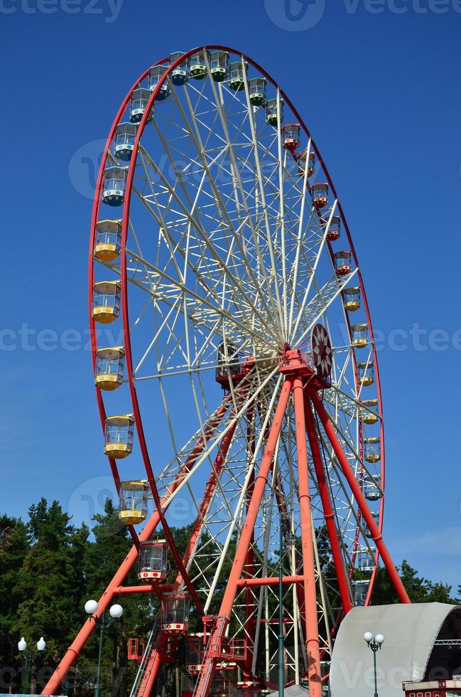 Big and modern multicolour ferris wheel on clean blue sky background photo