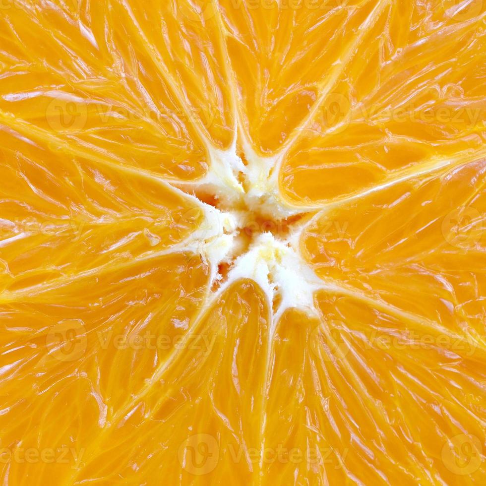 Top view of a fragment of the orange fruit slice close up. Macro background texture photo