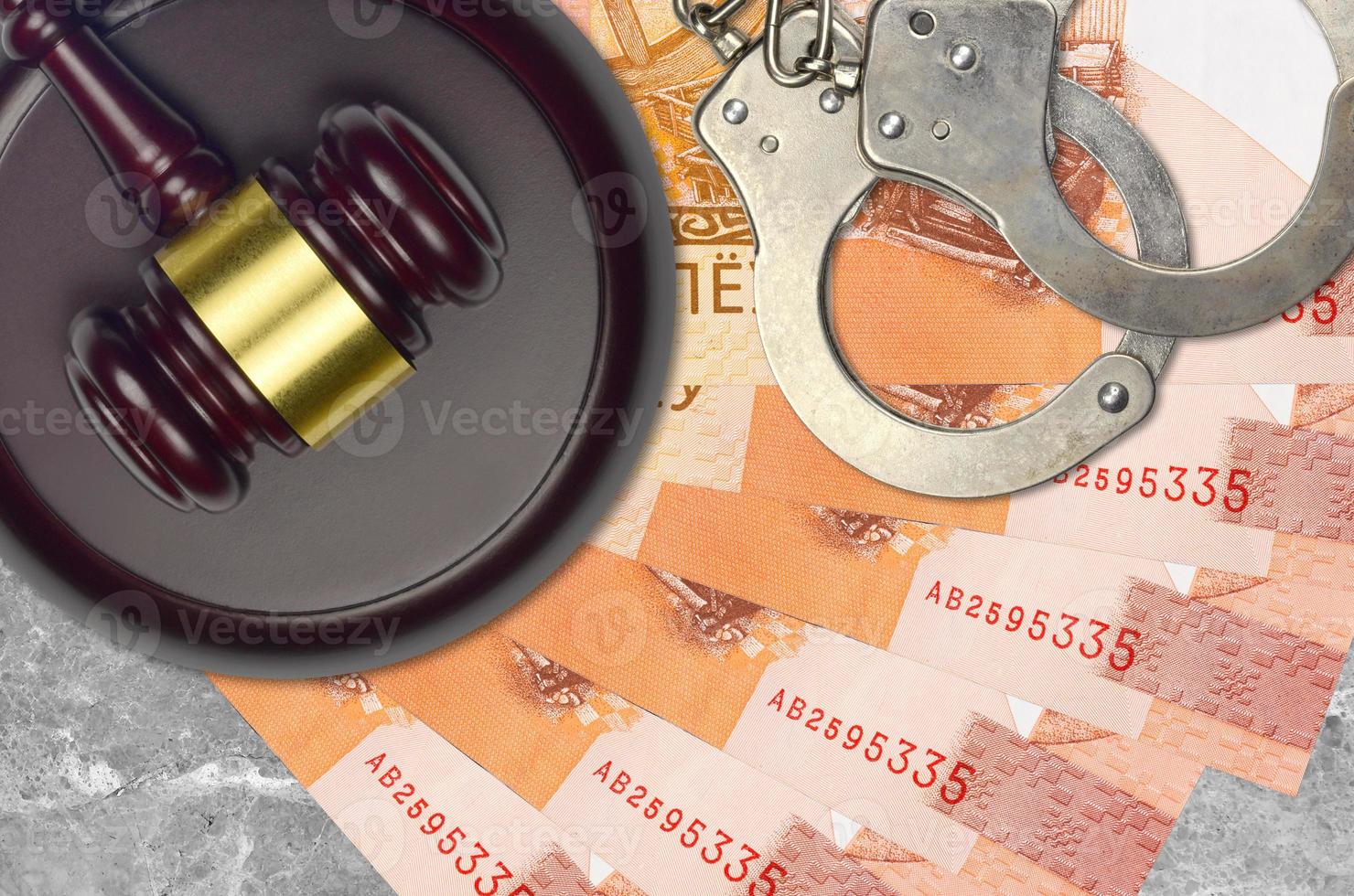 5 Belorussian rubles bills and judge hammer with police handcuffs on court desk. Concept of judicial trial or bribery. Tax avoidance photo