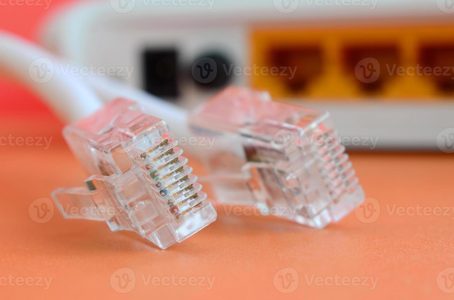 Internet router and Internet cable plugs lie on a bright orange background. Items required for Internet connection photo