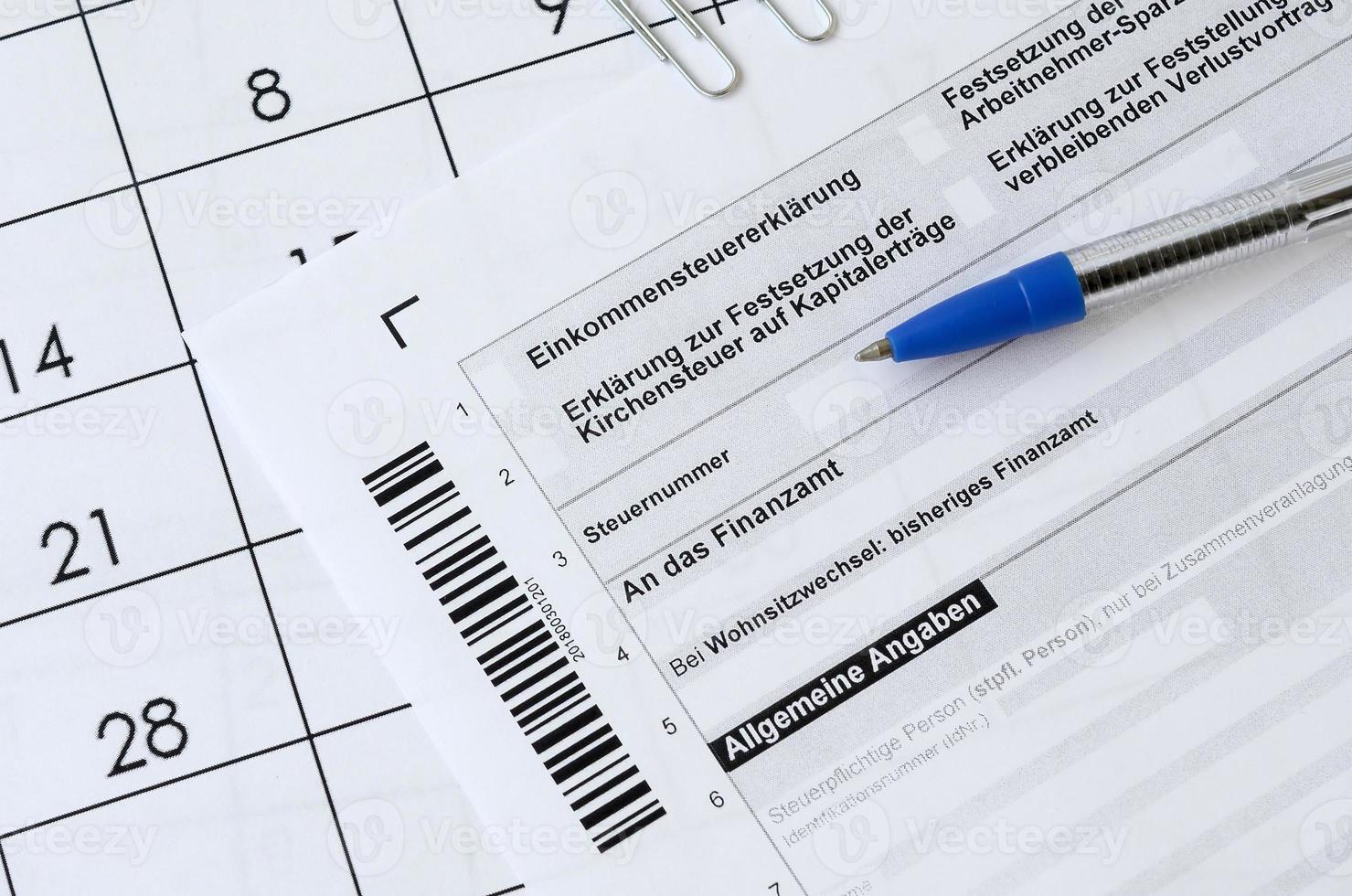 el formulario de impuestos alemán con bolígrafo se encuentra en el calendario de la oficina. concepto de pago de impuestos en alemania foto